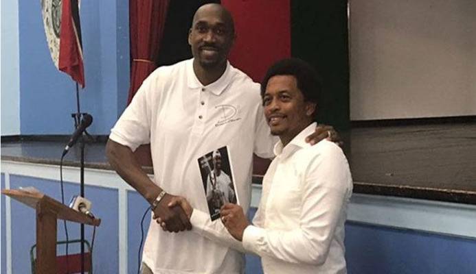 SHARING HIS EXPERIENCE: In this flashback photo, former pro basketballer Kibwe Trim, left, presents a copy of his book to TTOC president Brian Lewis at Trim’s alma mater, St Mary’s College, in 2017.